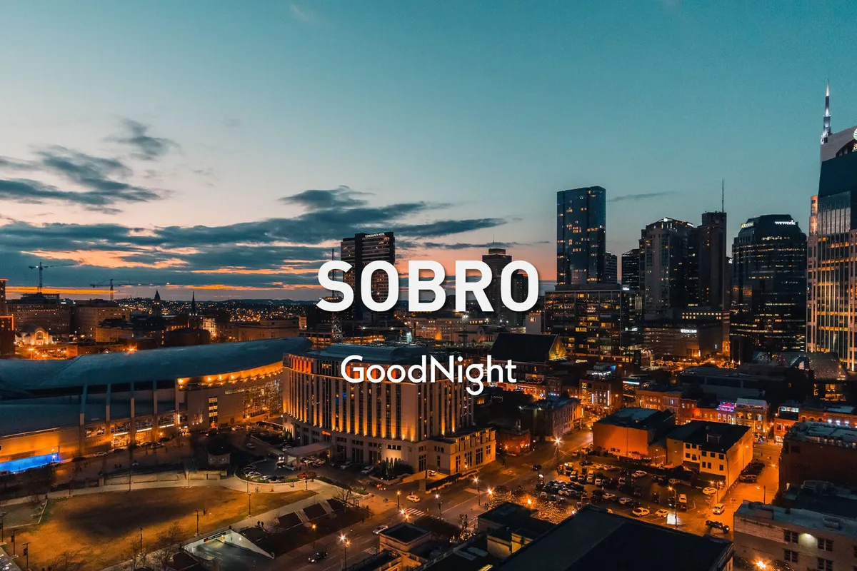 A panoramic view of the city skyline at sunset, with vibrant colors illuminating Nashville's urban architecture. The scene exudes a relaxed, welcoming mood, inviting couples and small groups to explore the city's nightlife and romantic ambiance.