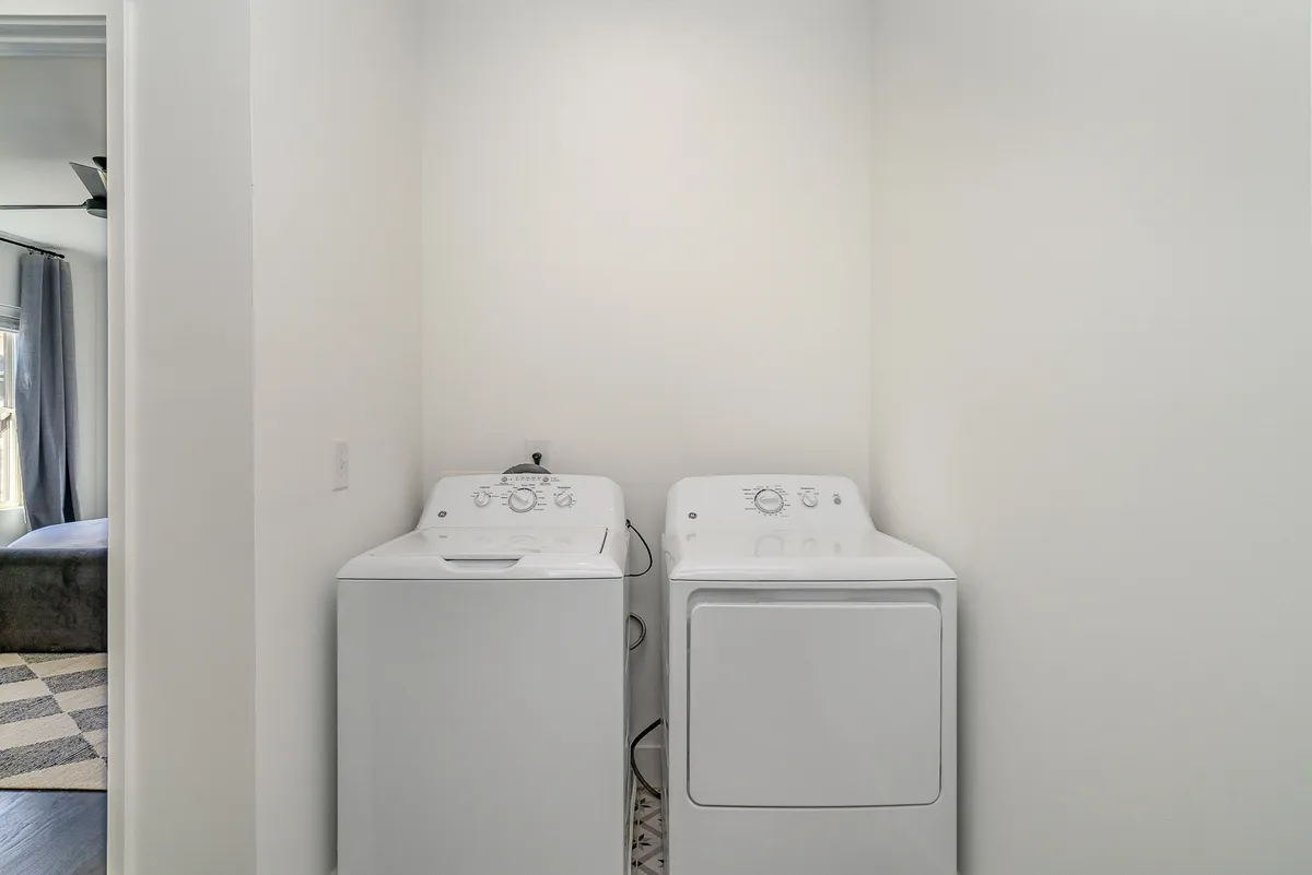A close-up of modern washing and drying machines side by side, emphasizing a practical setup for guests to manage their laundry and chores during their stay.